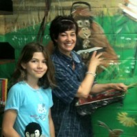 Silvia started out painting one wall of the library at St. Paul’s. The next thing she knew, the mural had spread out across the entire room. (Photo by Carol Lawless) Silvia started out painting one wall of the library at St. Paul’s. The next thing she knew, the mural had spread out across the entire room. (Photo by Carol Lawless)