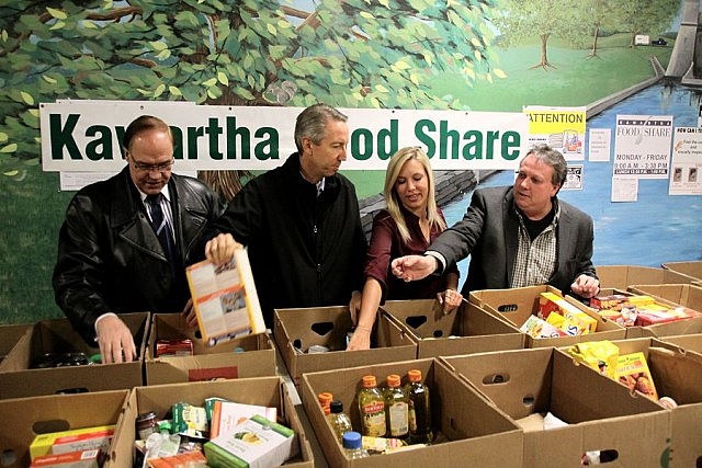 Mayor Daryl Bennett, Ashlee Aitken, Dennis Van Amerongen, and Terry Guiel take a few minutes to participate in a food sort. The City of Peterborough's donation will allow Kawartha Food Share to purchase almost $70,000 worth of food for families in the City and County of Peterborough. (Photo: Jeannine Taylor / kawarthaNOW)