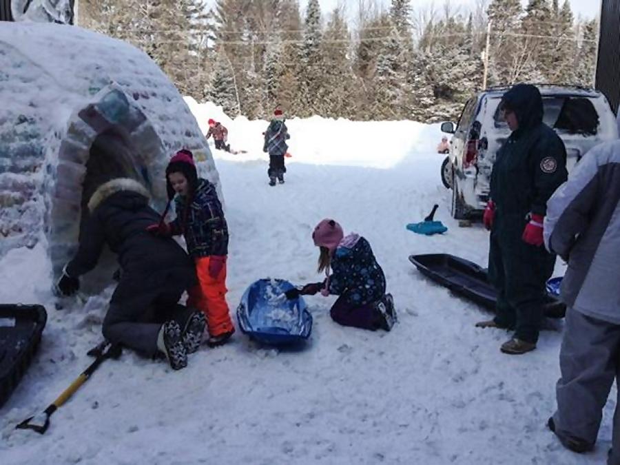 Volunteers digging the snow out of the completed igloo