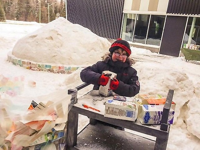 A young volunteer peeling a carton away from an ice brick