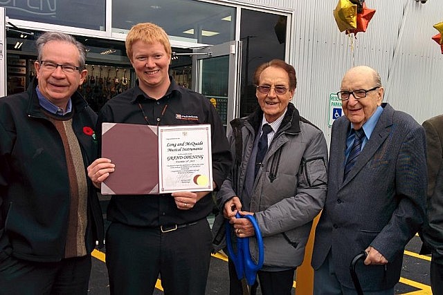 Peterborough MPP Jeff Leal presents store manager Daryl Guy with a congratulatory certificate. Also pictured are former Bud's Music owner Bud Monahan and Long & McQuade founder Jack Long
