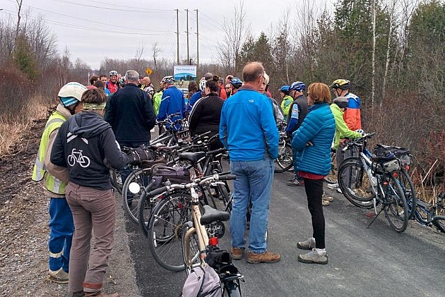 A crowd of cyclists and others gather for the official trail opening on November 10