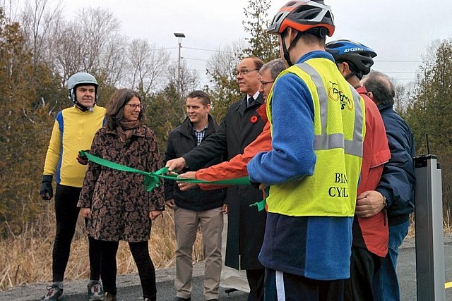 The official ribbon cutting with cyclists Rick and Dave, Susan Sauve, Michael Goodyear, Daryl Bennett, Keith Riel, and more